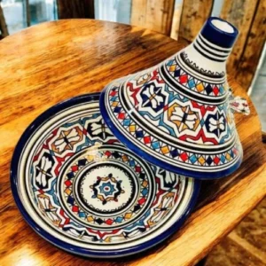 Hand-painted decorative Moroccan tajine with intricate patterns and vibrant colors, used as a traditional centerpiece or home décor.